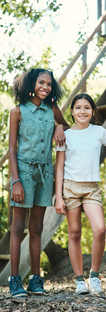 Zwei Mädchen vor einer Holztreppe